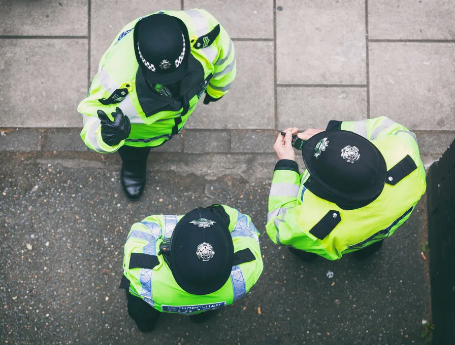 Tři policisté v reflexních vestách v ulici